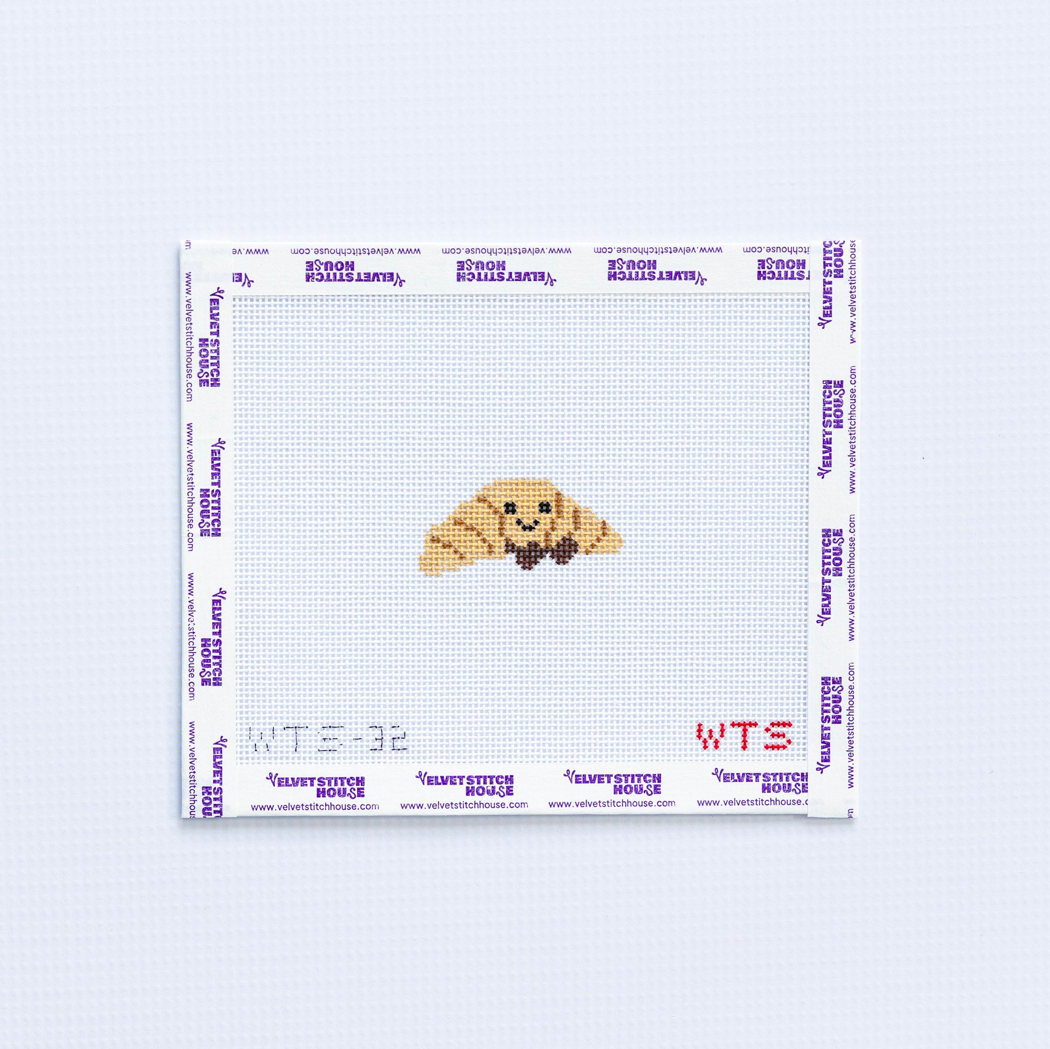 Mini needlepoint pattern with a smiling croissant design on a white background