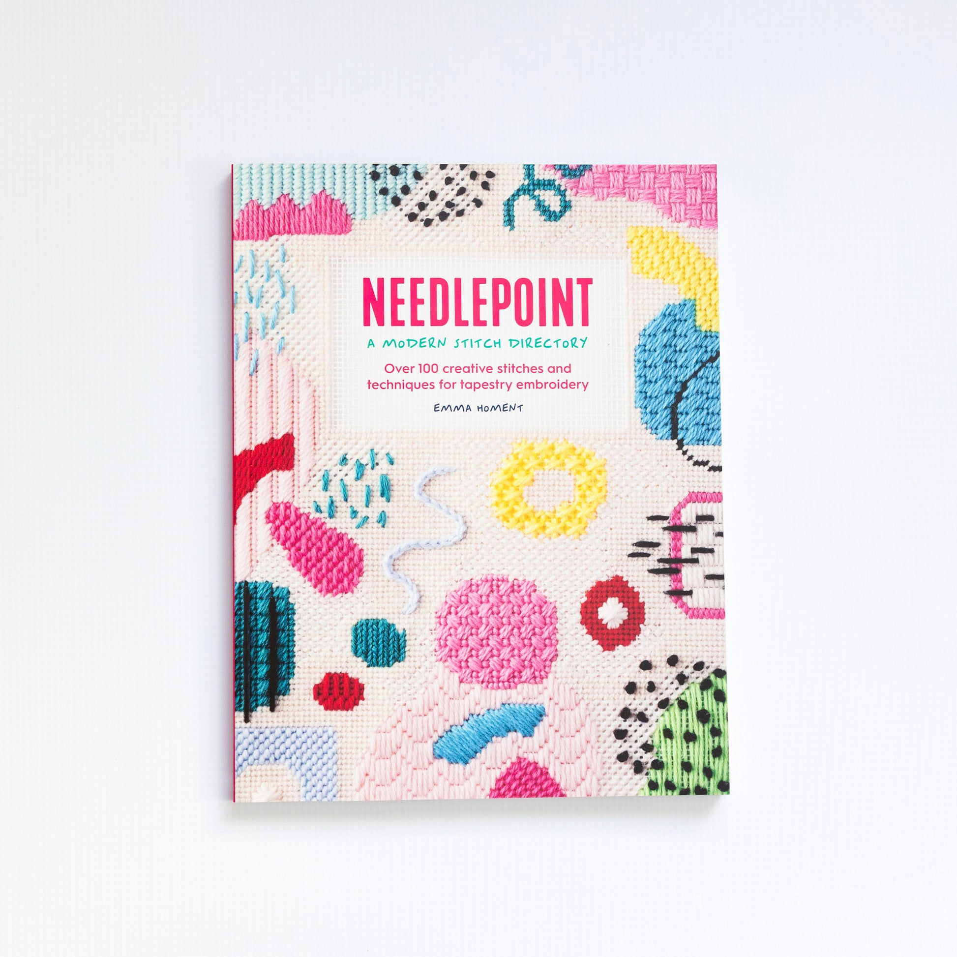Book titled 'Needlepoint a Modern Stitch Directory" with colorful needlepoint patterns on a white background