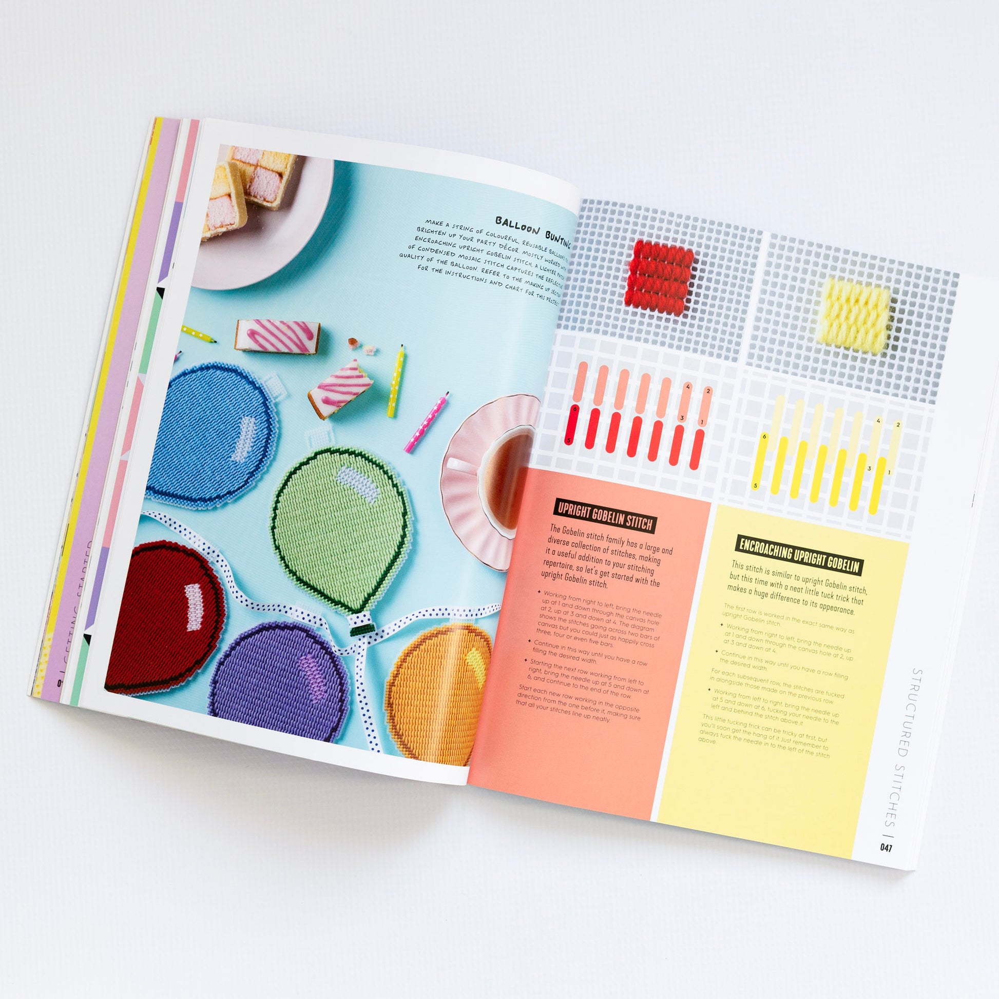Open book with colorful needlepoint patterns and instructions on a white background