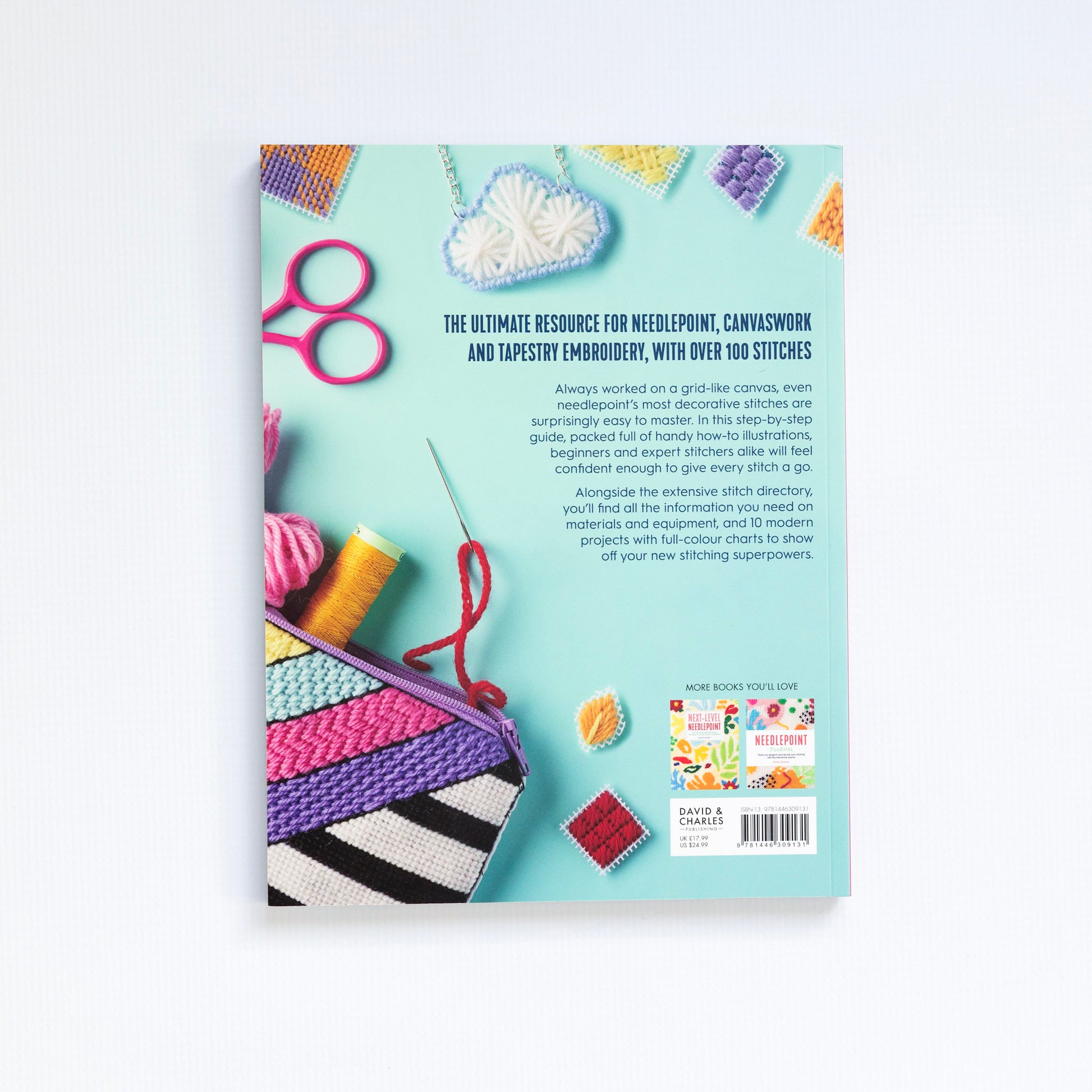 Book cover with needlepoint and embroidery tools on a light blue background