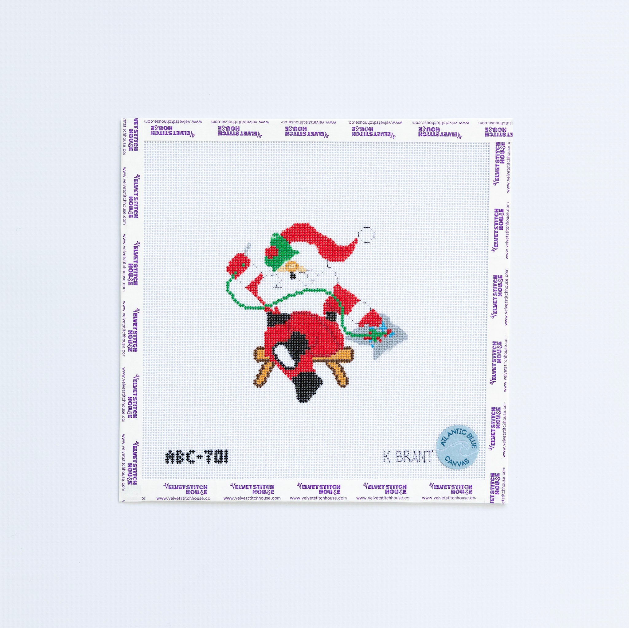 Needlepoint design of a santa with a red hat needlepointing with green thread. 