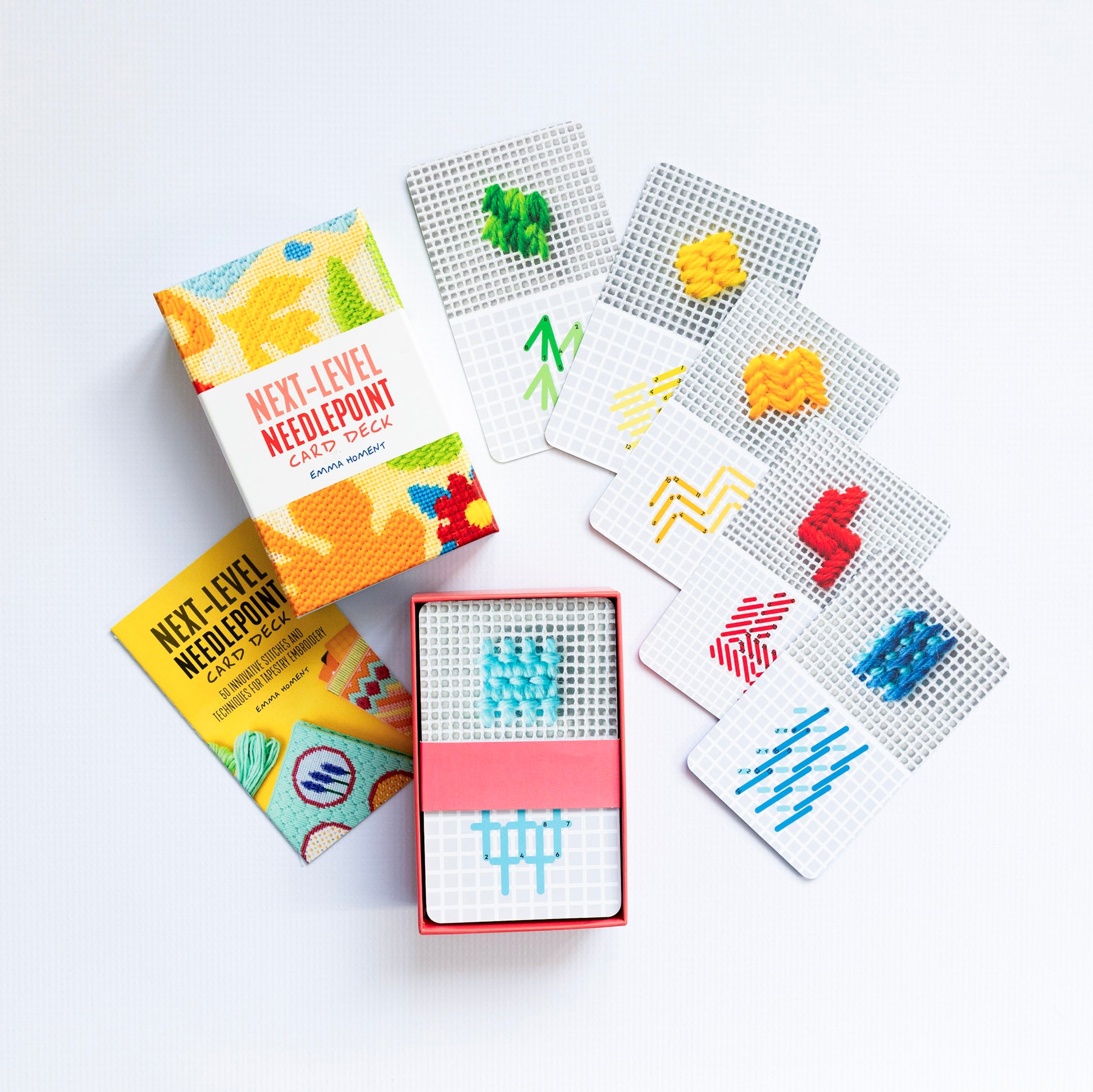 Colorful needlepoint design cards with packaging on a white background