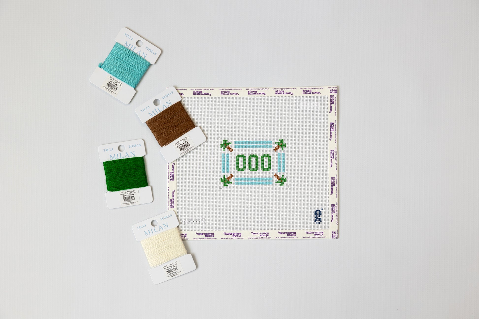 Needlepoint kit with a pre-printed pattern on fabric and color swatches.