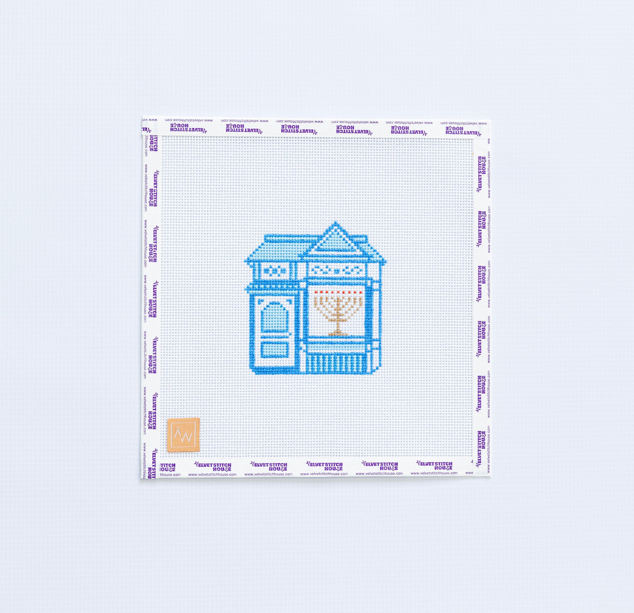 Needlepoint pattern with a blue house with a gold menorah in the window design on white background.