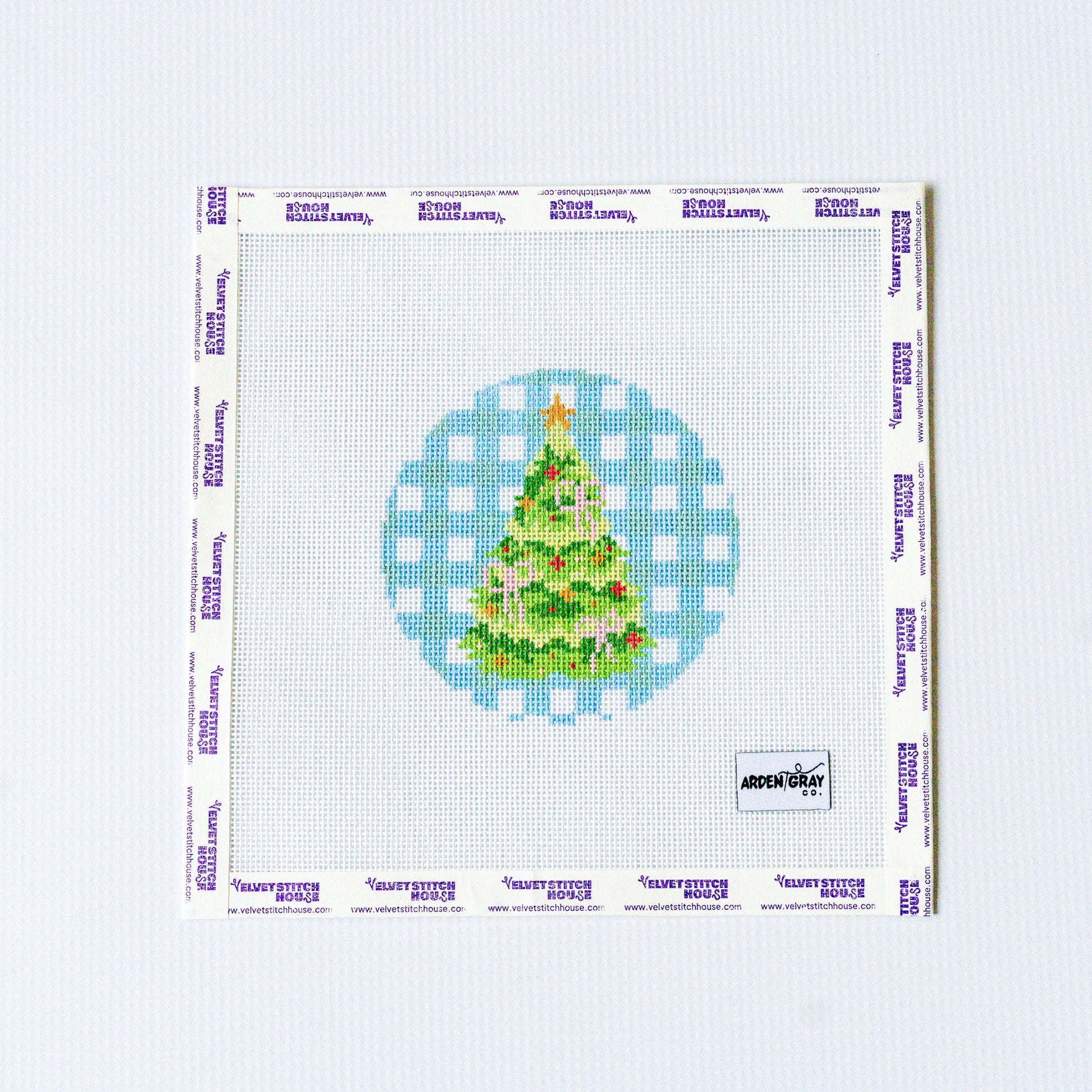 Needlepoint pattern of a green Christmas tree design with pink bows on a blue gingham backround