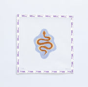 Needlepoint pattern with a brown snake design on a light blue  background