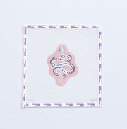 Needlepoint pattern of a white snack on a light pink background