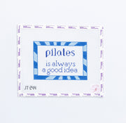 Needlepoint design with 'pilates is always a good idea' text and blue border on white background