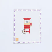 Needlepoint design of a red popcorn machine on a white fabric with a white background