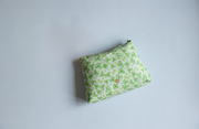 Green floral pouch on a light gray background