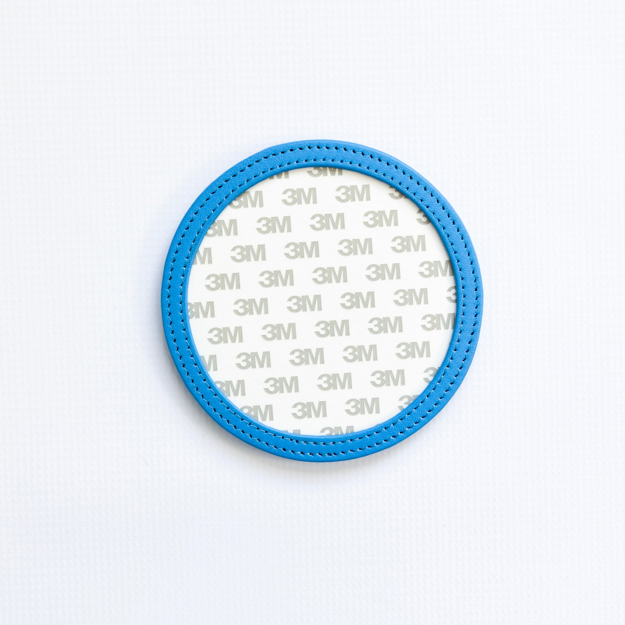 Blue circular coaster with 3M branding on a white background