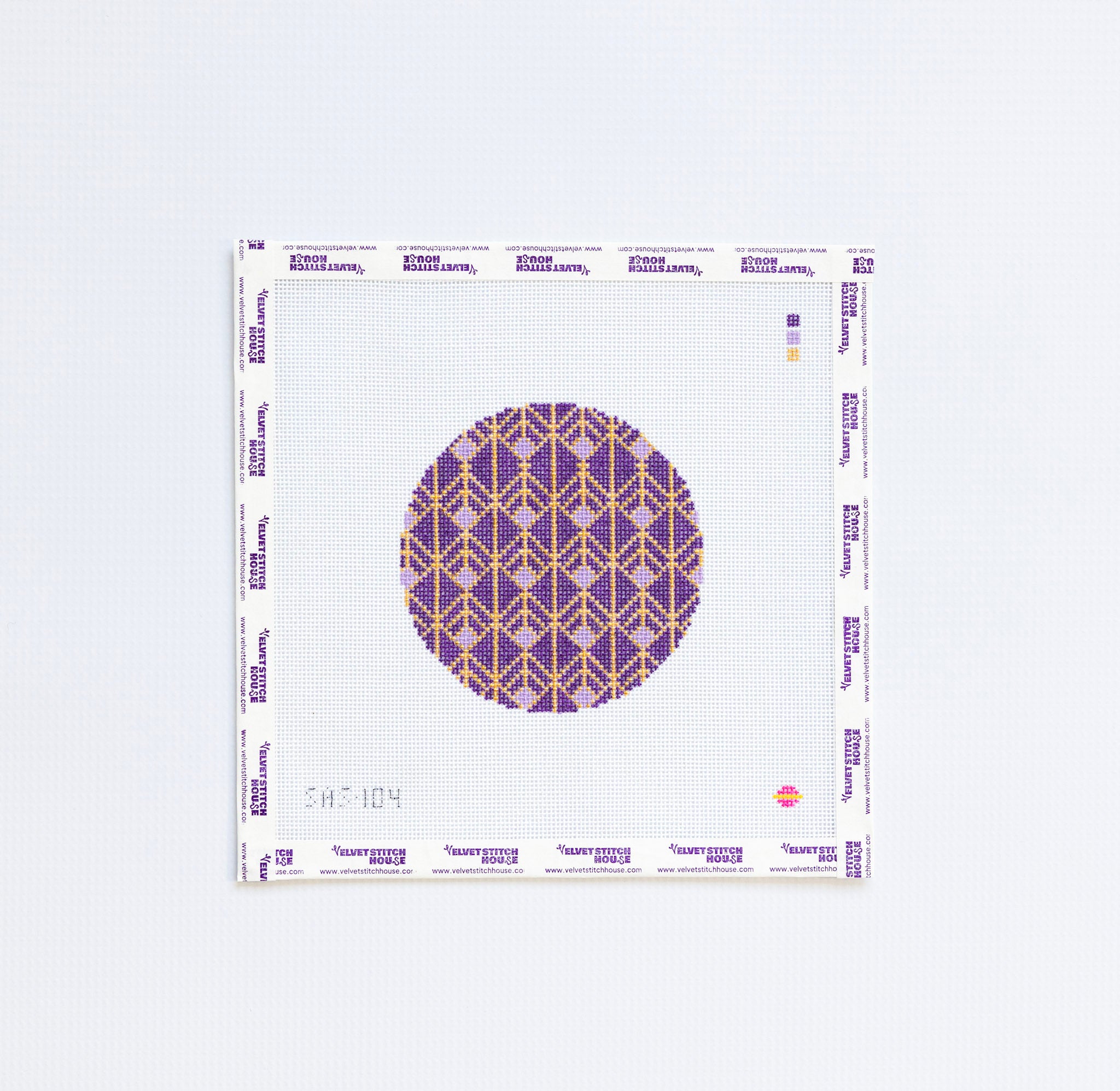 Needlepoint pattern with a purple circle and gold design on a white background
