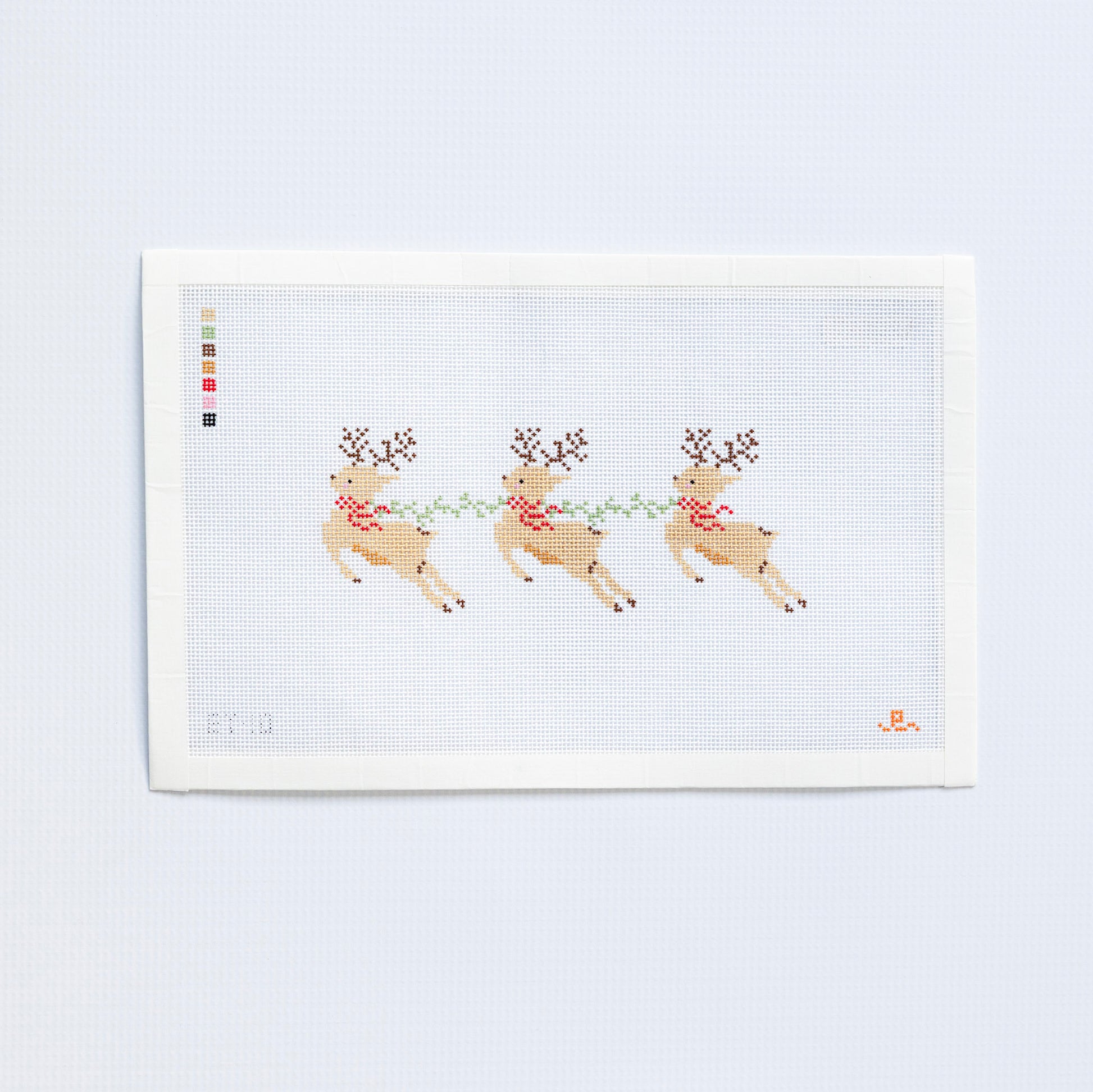 Needlepoint pattern of three reindeer with antlers on a white background