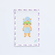 Needlepoint pattern of a cat with sunglasses and a towel on a white background