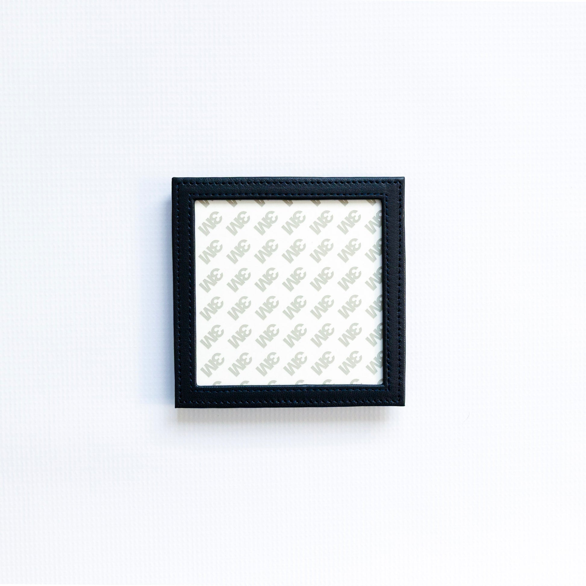 Small navy self finishing square coaster on a white background