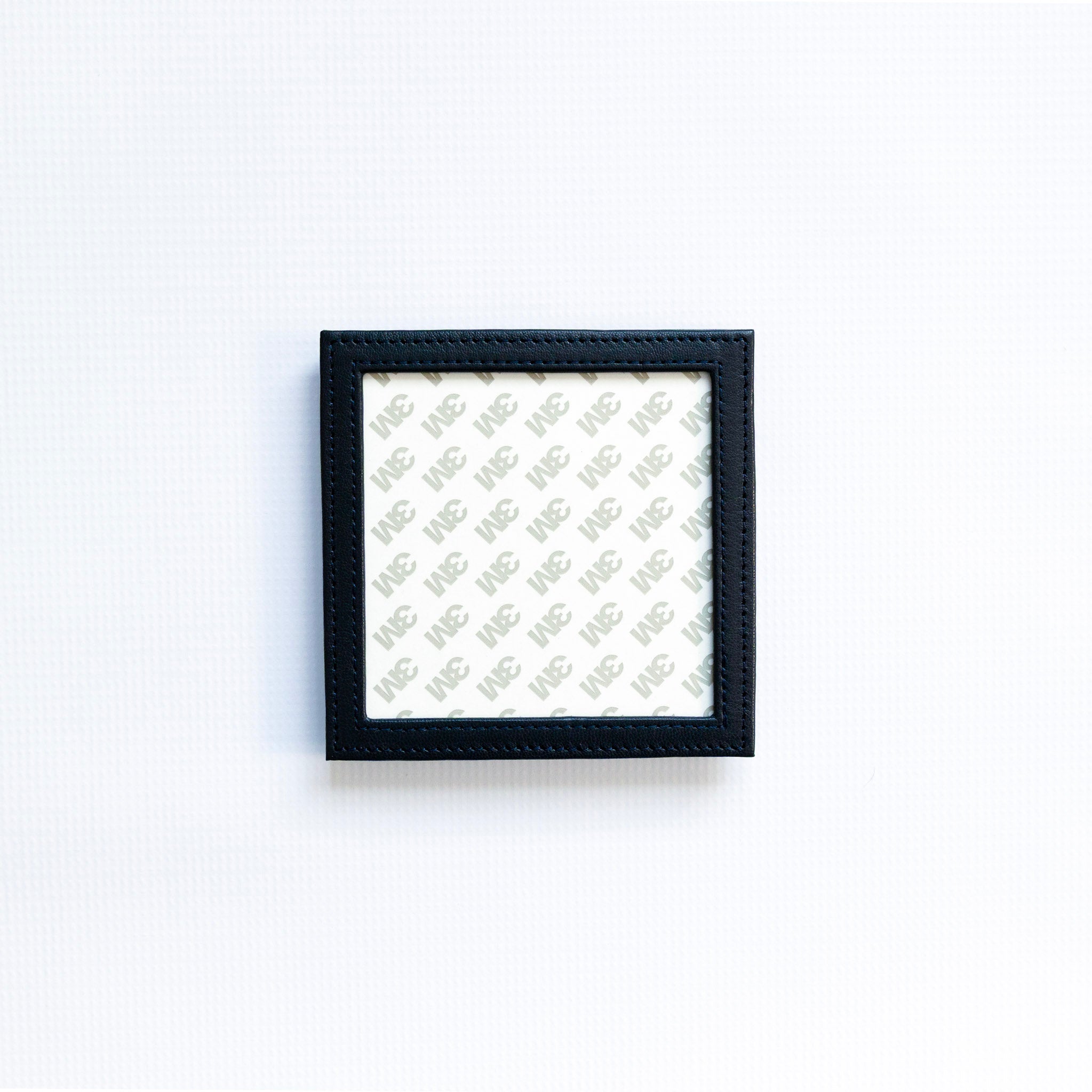 Small navy self finishing square coaster on a white background
