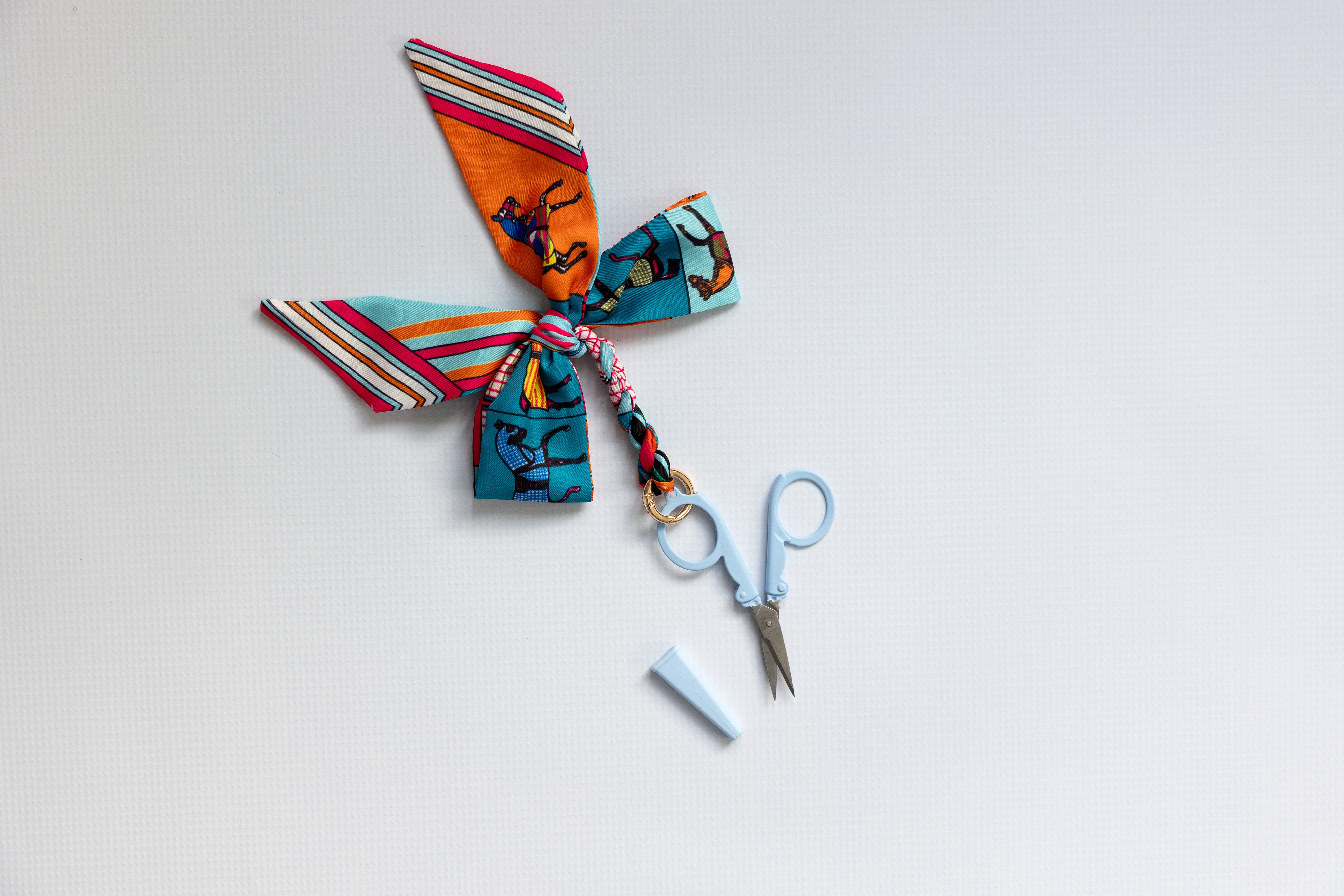Colorful fabric bow with decorative elements on a light gray background