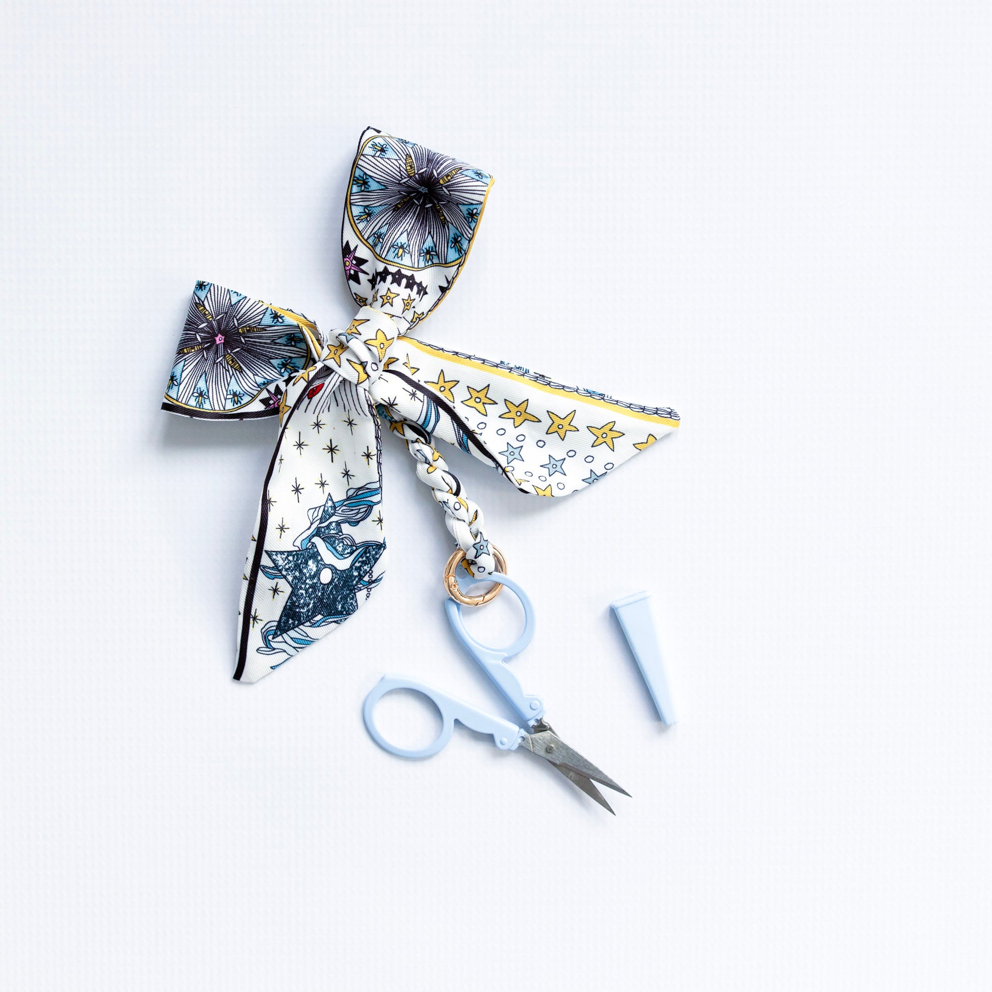 Decorative bow with star pattern and scissors on a white background