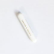 White cylindrical container with 'Thread a Needle' text on a white background