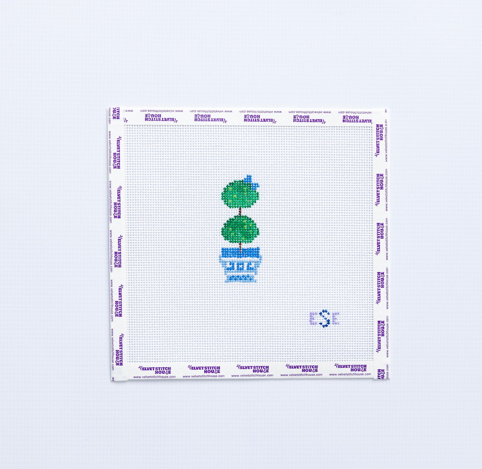 Needlepoint pattern with a green topiary tree in a blue pot on a white background