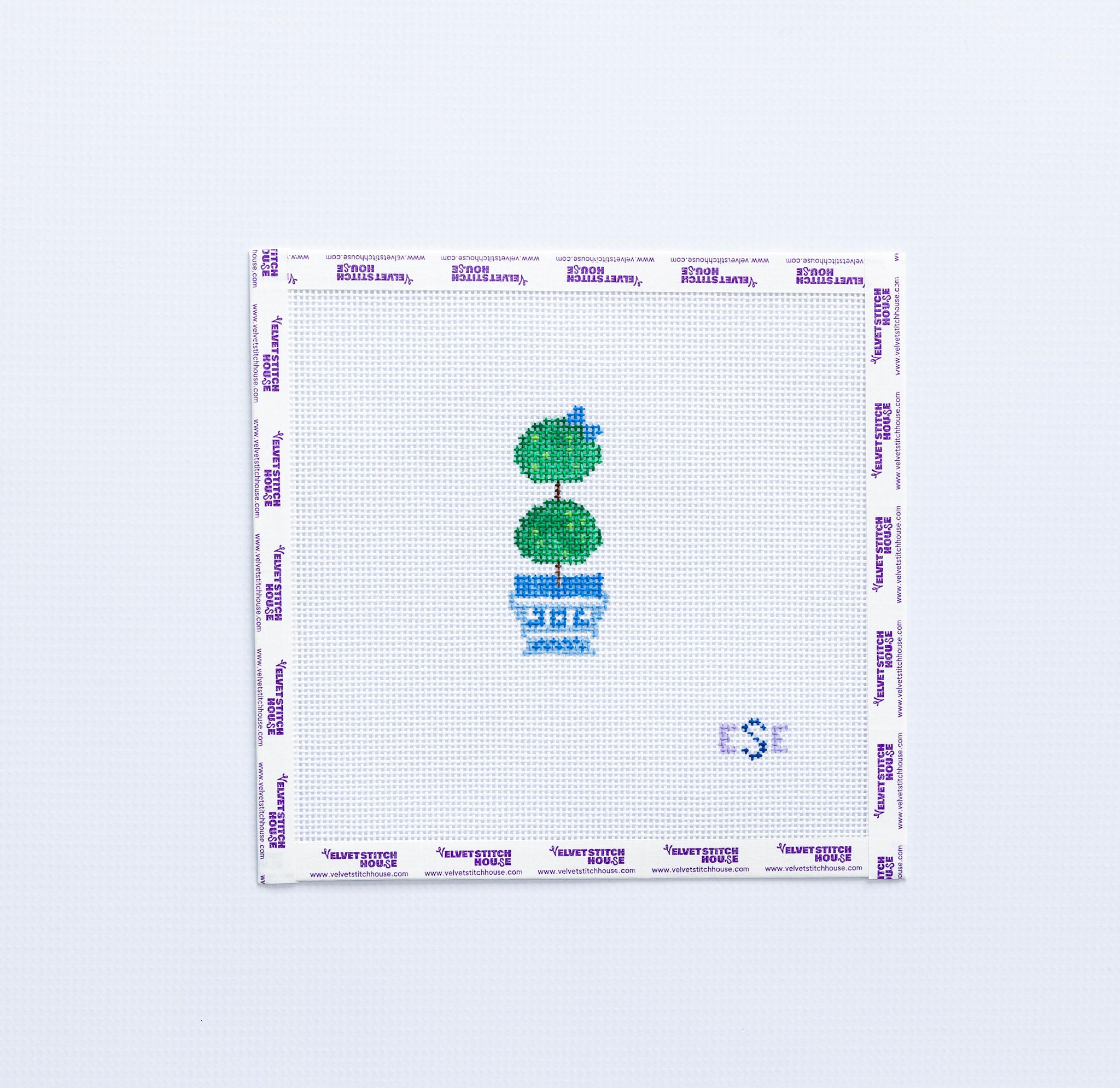 Needlepoint pattern with a green topiary tree in a blue pot on a white background
