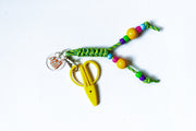 Colorful keychain with yellow scissors on a white background