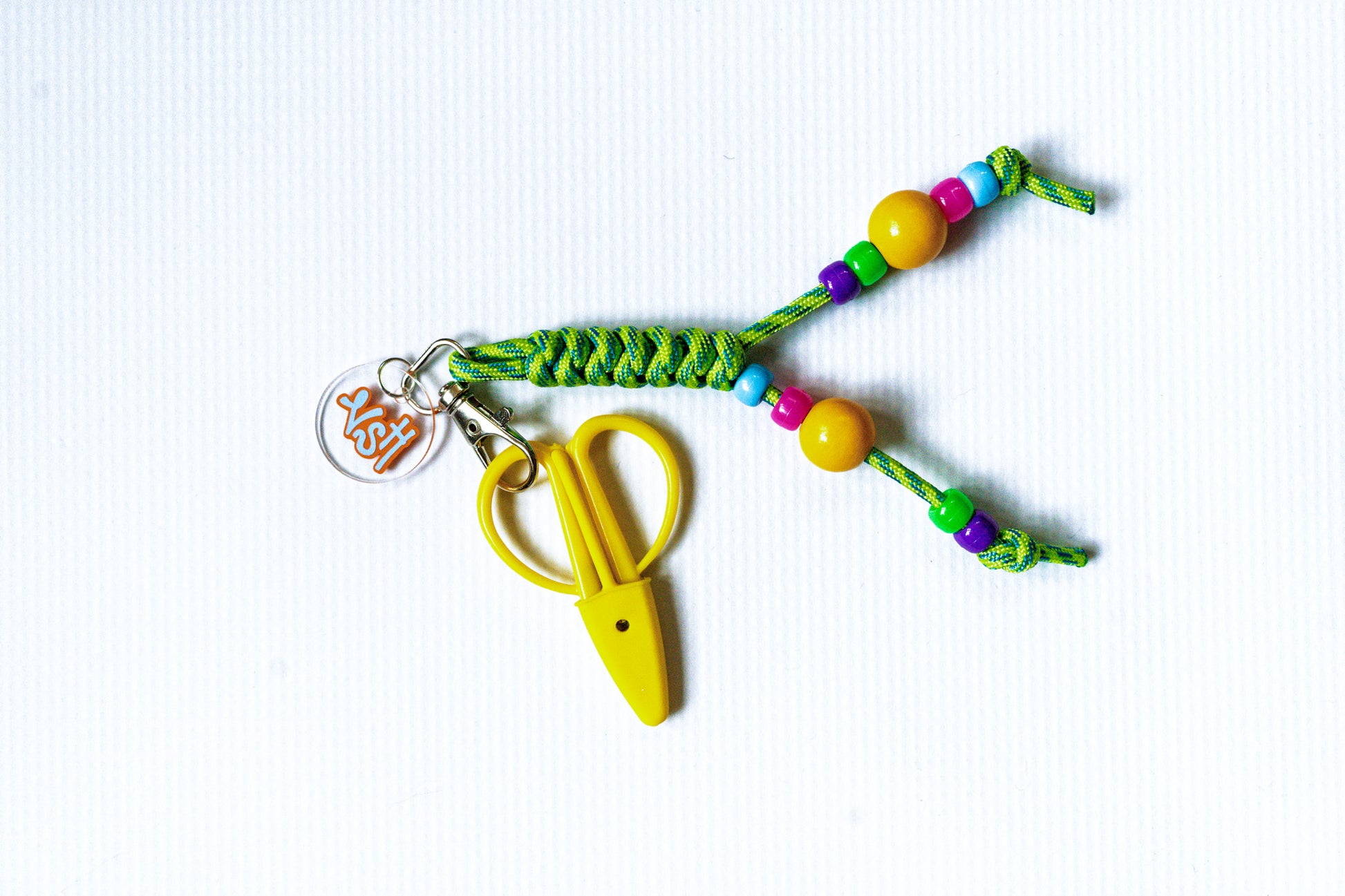 Colorful keychain with yellow scissors on a white background
