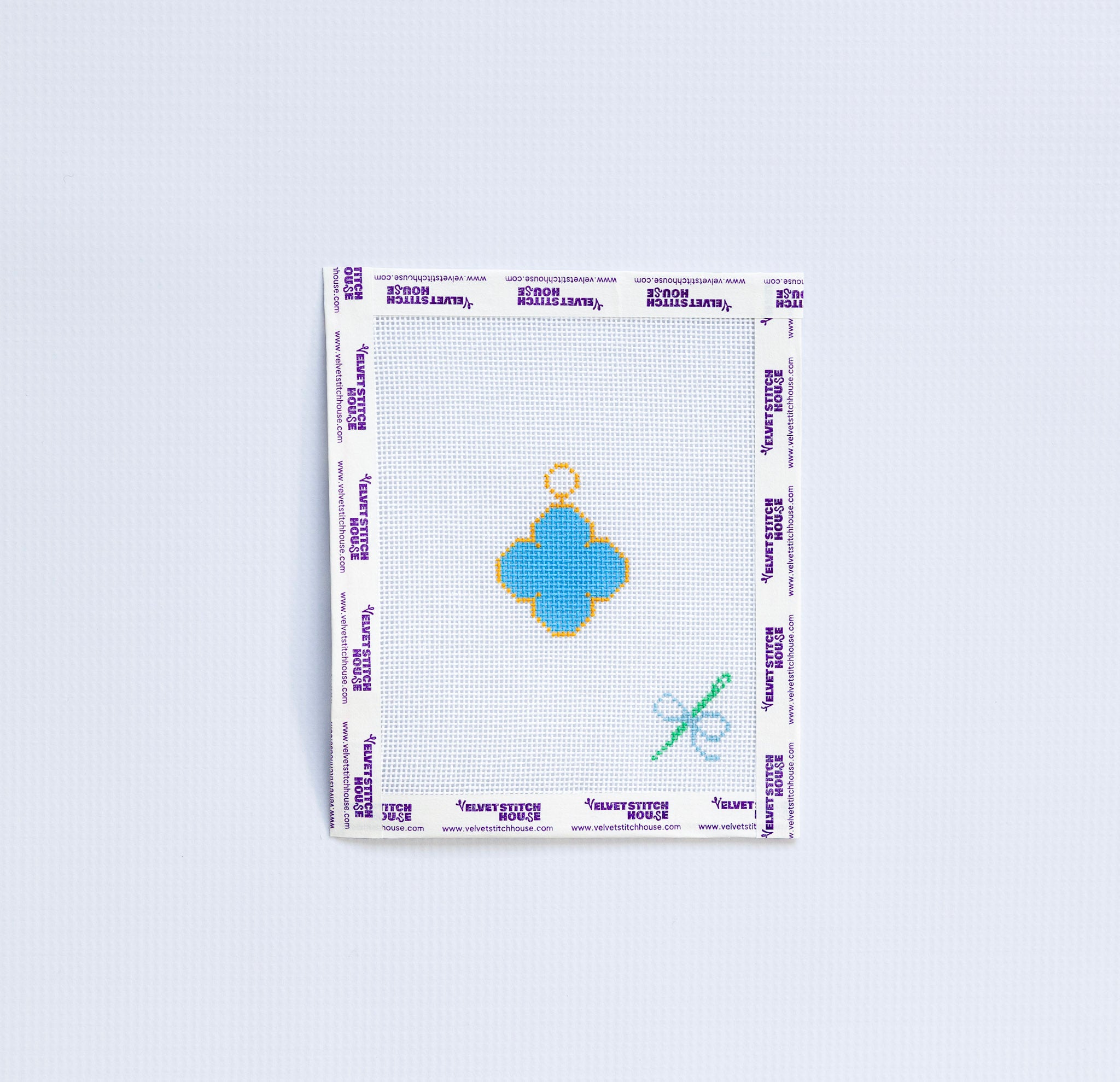 Needlepoint pattern with blue van cleef charm on white background