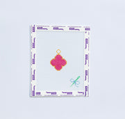 Needlepoint pattern with a pink van cleef design on a white fabric swatch.