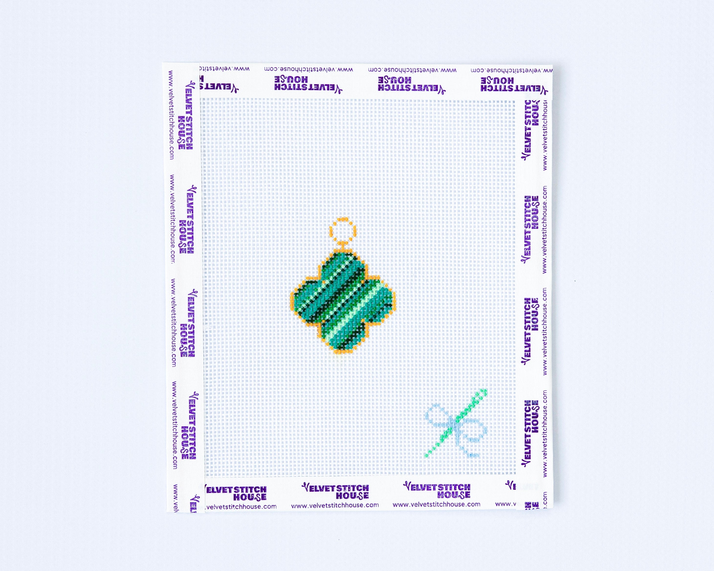 Needlepoint pattern with a green van cleef design on a white background
