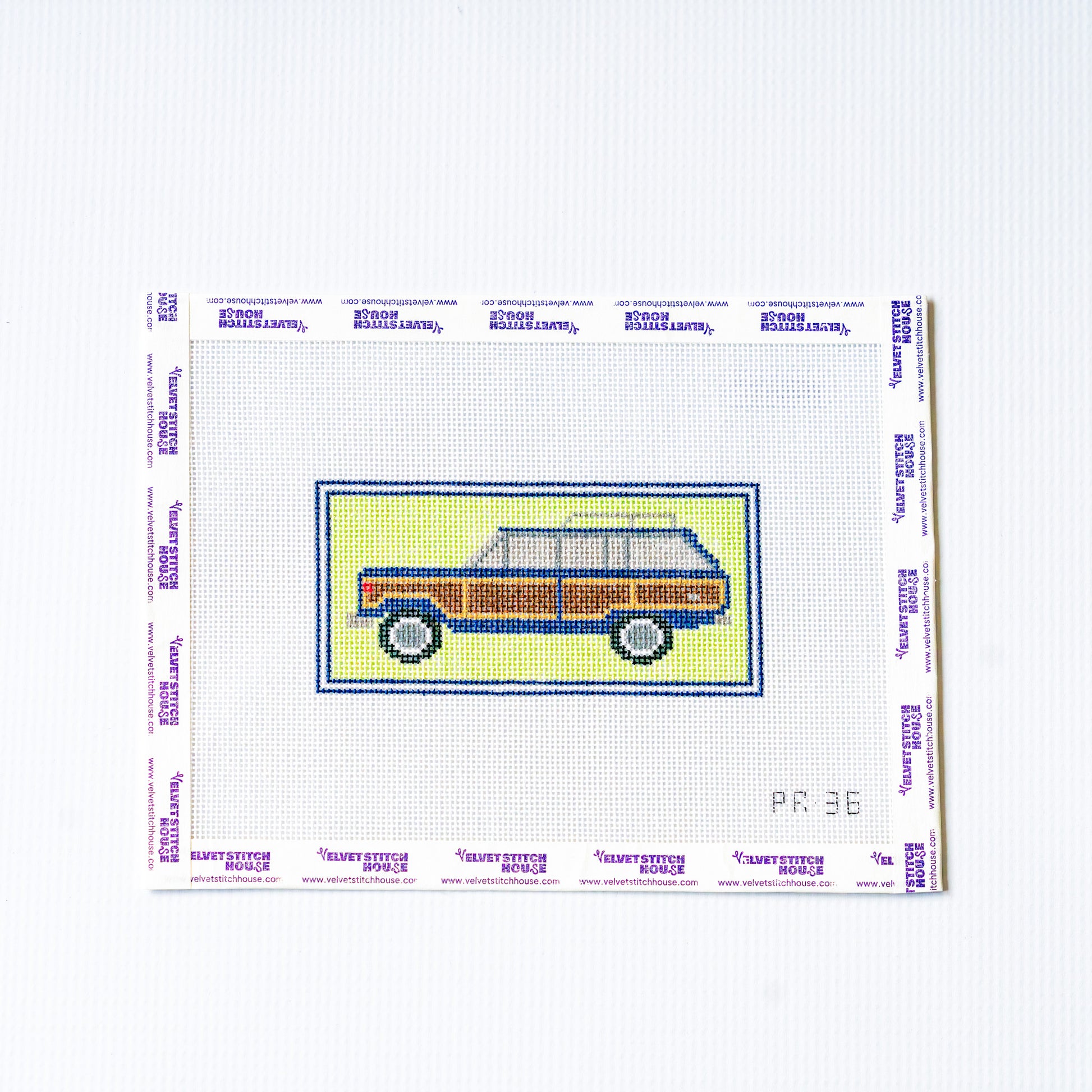 Needlepoint design of a vintage car on canvas with a white background