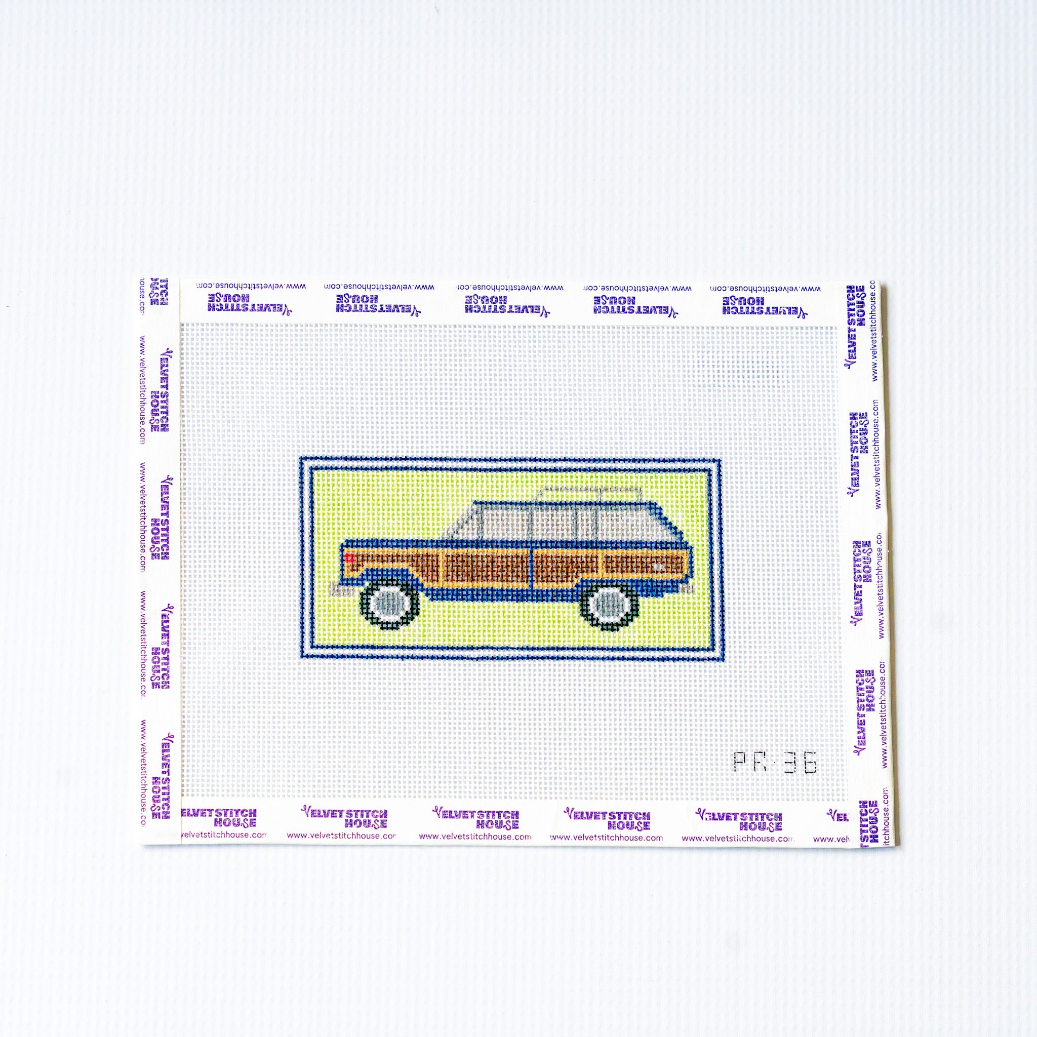 Needlepoint design of a vintage car on canvas with a white background