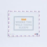 Needlepoint pattern with "Where the WIld Thing Sleeps" text in light gray and gold crown on a white background