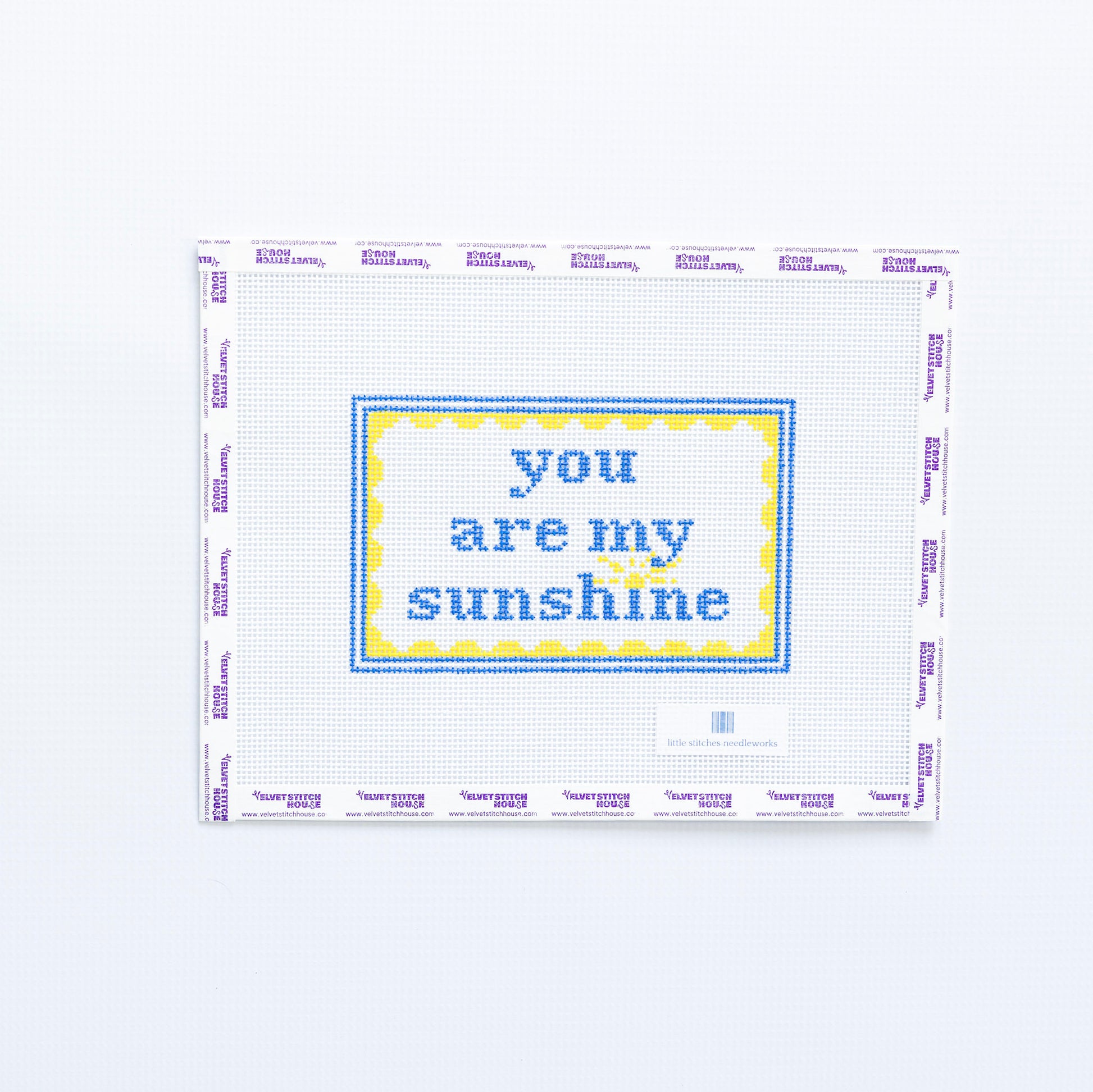 Needlepoint design with 'you are my sunshine' in blue text with a yellow scallop frame on a white background