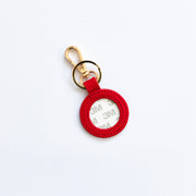Red keychain with a gold ring on a white background