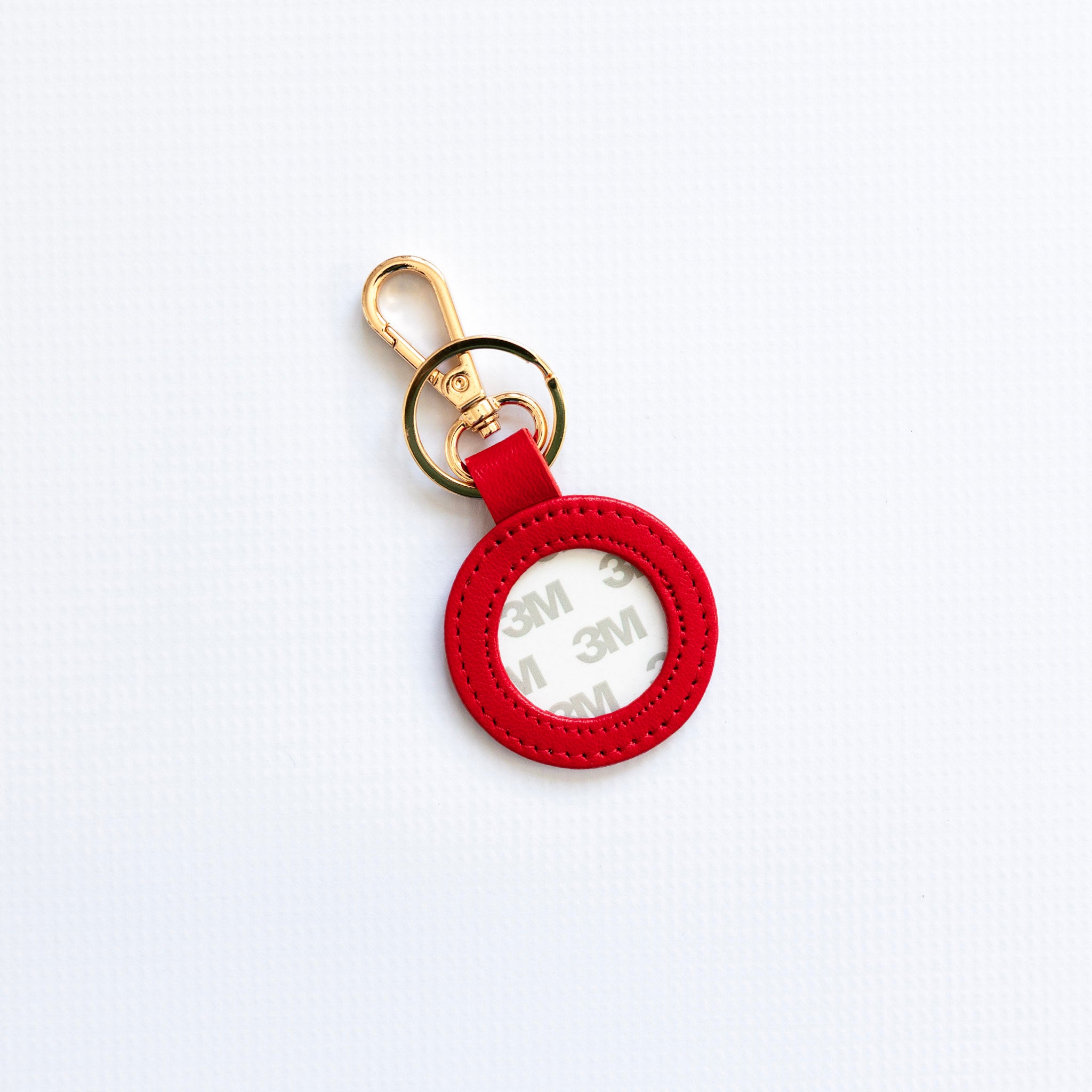 Red keychain with a gold ring on a white background